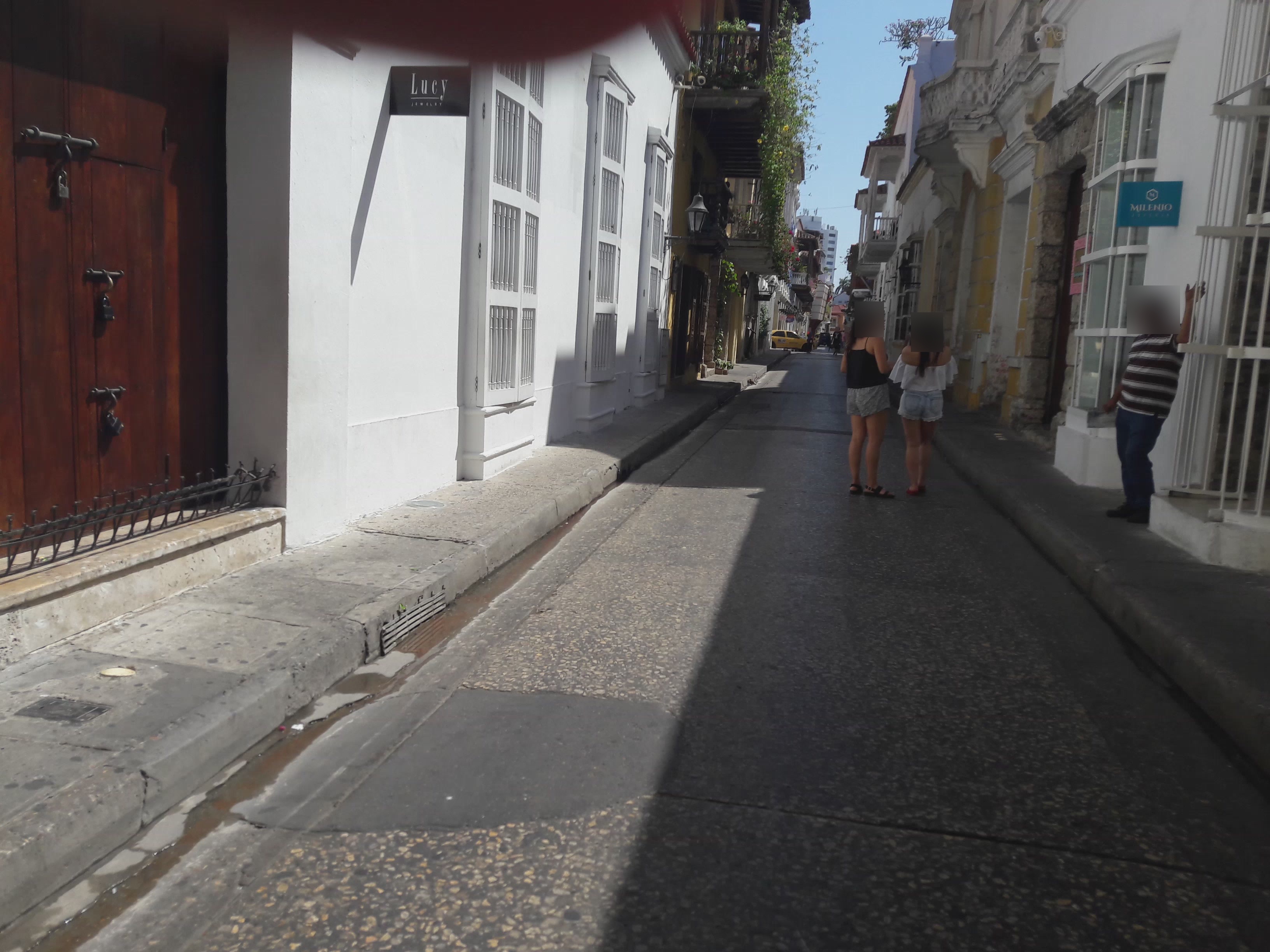 Example street-level photo with colorful buildings, road, and utility lines — location intentionally hidden